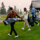Three people walking on golf course carrying the E-Series bags
