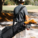 Man carrying a black Matchplay Ballistic golf bag
