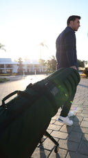 Man pulling a Green-Black ClubGlider Meridian outside 