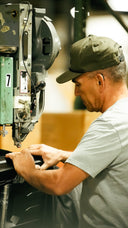 Man at rivet machine in Sun Mountain warehouse