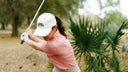 Woman playing golf with a blurred green background