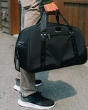Man holding the Matchplay Ballistic duffel in black