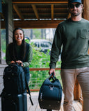 Woman on the left with the Matchplay Ballistic Carry-on and Backpack and man to the right carrying the Matchplay Ballistic duffel in black