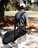 Man walking on a golf course carrying a Matchplay Ballistic golf bag