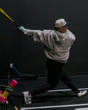 Man hitting the Victus Pencil bat with a Sun Mountain x Victus golf bag to the side