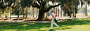 Man walking along the course carrying a Sun Mountain Matchplay bag