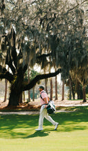 Man walking along the course carrying a Sun Mountain Matchplay bag