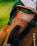 Close-up of a brown TQR waxed canvas golf bag with Sun Mountain branded patch