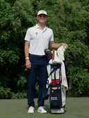 Bennett Swavely in golf attire standing next to a golf bag on a golf course