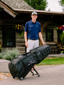 Ryggs Johnston outside of a cabin at Rock Creek golf course with the ClubGlider3 Tour travel bag