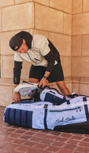 Person loading a Sun Mountain x Bad Birdie Clubglider bag 