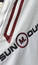 Close-up of a white golf bag with red and black Sun Mountain and MUNICIPAL branding