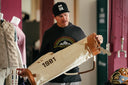 Joel Dahmen holds a vintage cream-colored canvas Sun Mountain golf bag with brown leather trim and the year '1981' printed on it